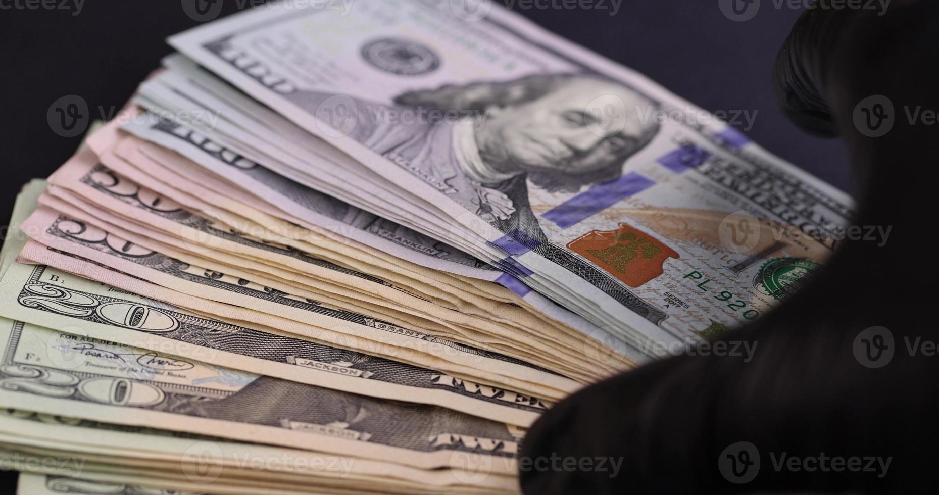 espalhar notas de dólar americano em papel preto foto