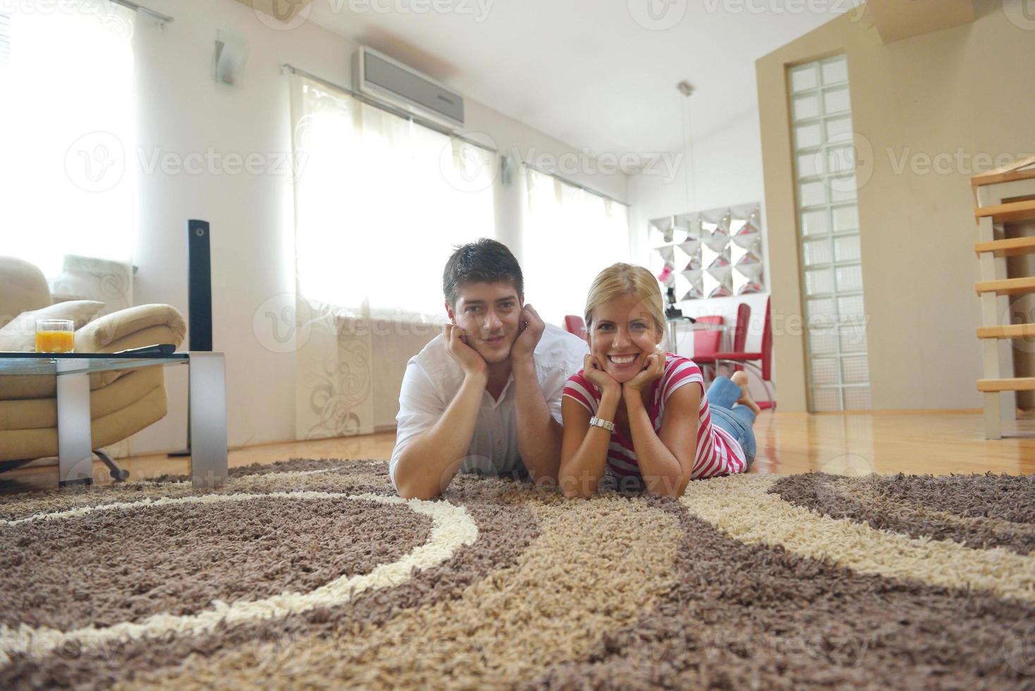 jovem casal relaxado assistindo tv em casa foto