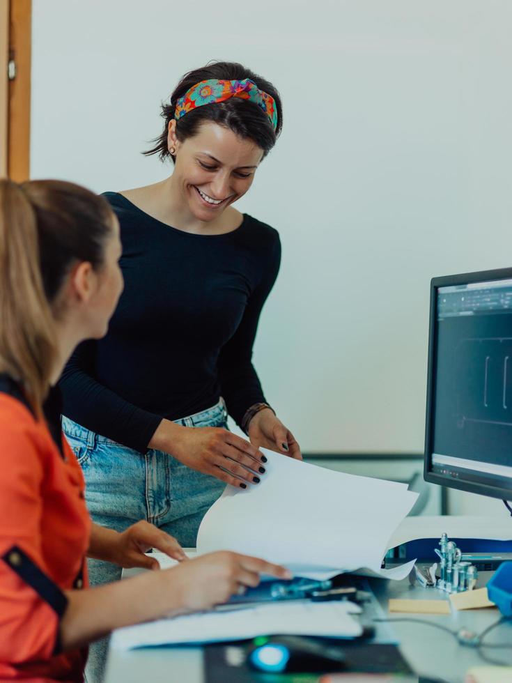 dentro da indústria pesada, um engenheiro industrial de fábrica mede com um paquímetro e em um computador pessoal projeta um modelo 3d foto