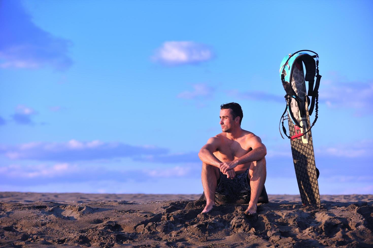 retrato de um jovem kitsurf na praia ao pôr do sol foto