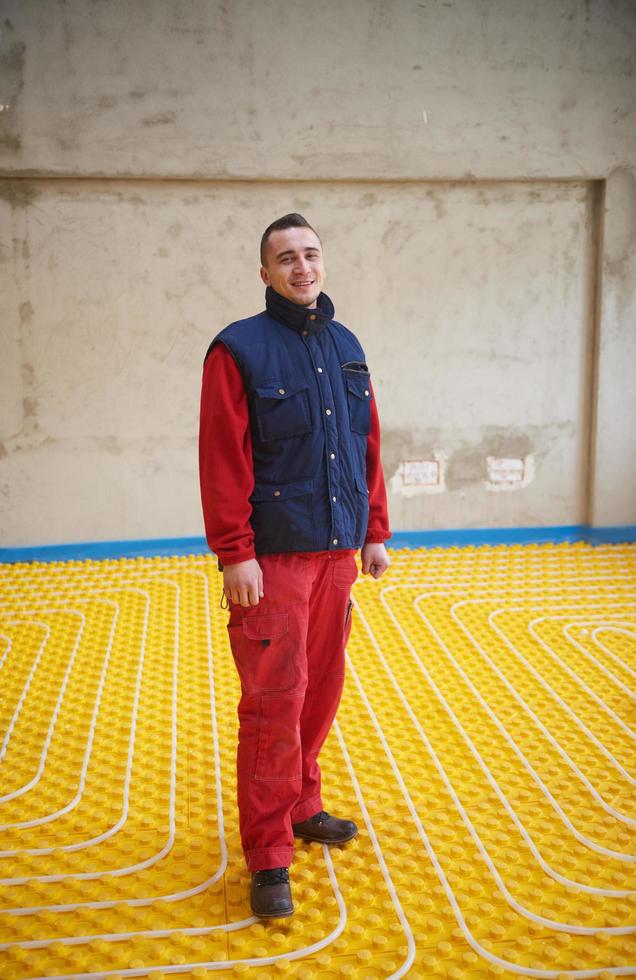 trabalhadores instalando sistema de piso radiante foto