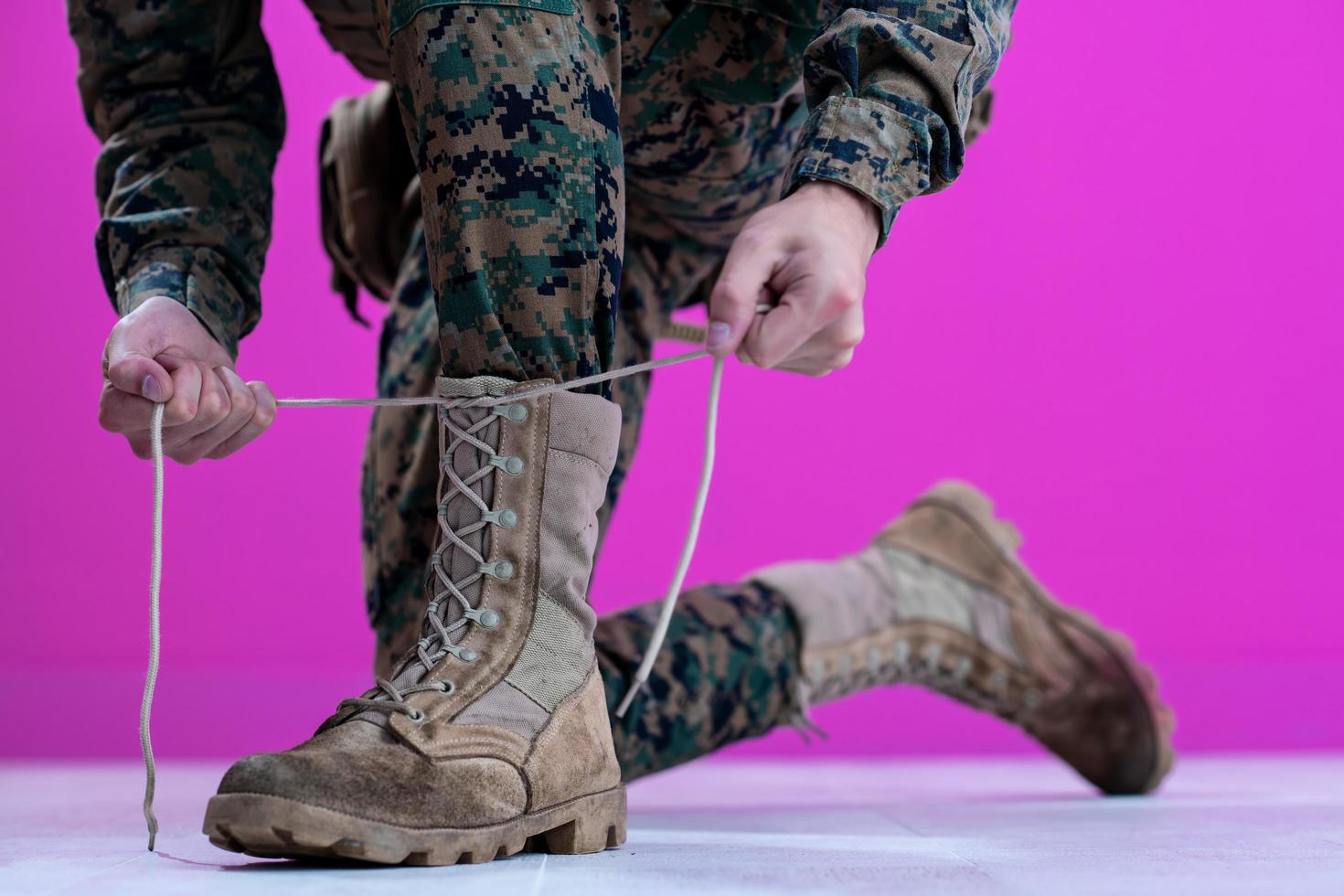 soldado amarrando os cadarços em suas botas foto