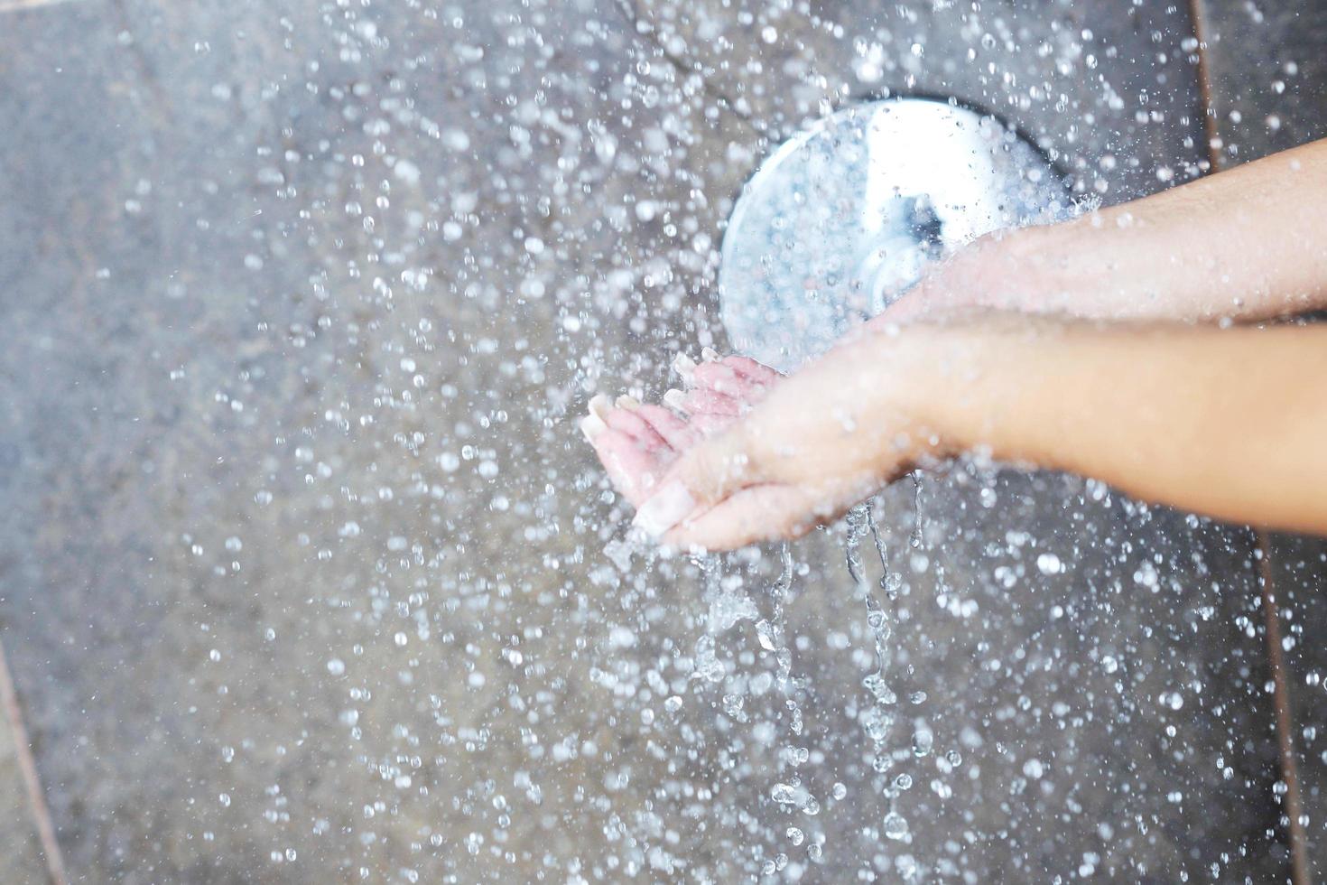 sexy jovem desfrutando de banho sob o chuveiro de água foto