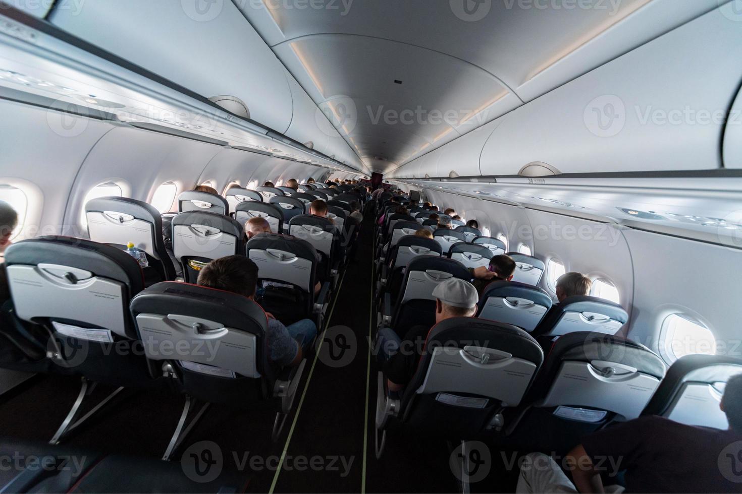 assentos de cabine de avião com passageiros. classe econômica das novas companhias aéreas de baixo custo mais baratas. viagem de viagem para outro país. turbulência em voo. foto