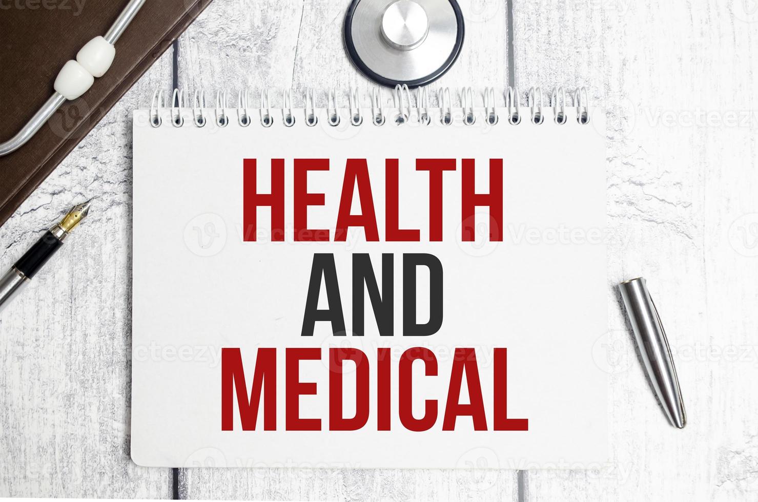 saúde e palavras médicas no bloco de notas e estetoscópio foto