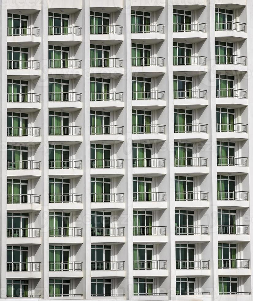 um padrão repetitivo de janelas e uma varanda. janelas de um edifício de hotel. foto