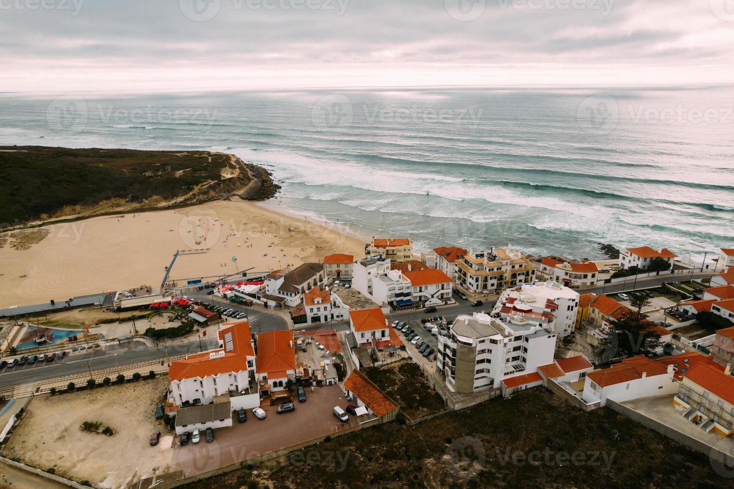 vista aérea de drone da cidade costeira de portugal com casas no mercado imobiliário em sintra, lisboa, europa, propriedades no topo da falésia e casas na costa com vista para o mar na praia das macas foto