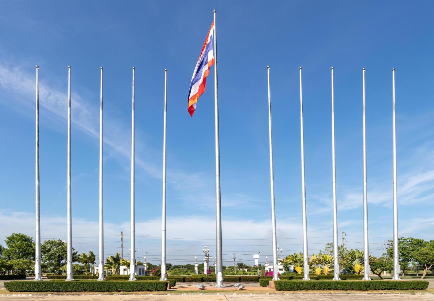 bandeira tailandesa nos postes com nuvem de céu azul e árvore na parte de trás. foto