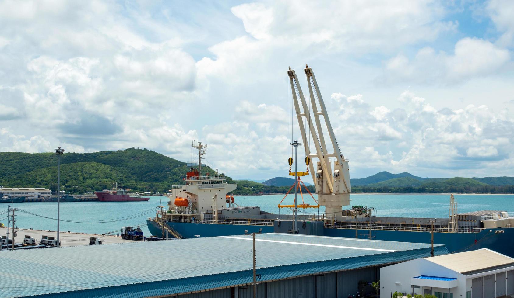 guindaste portuário industrial levanta carregamento de caixa de contêineres de exportação a bordo no porto da tailândia. foto