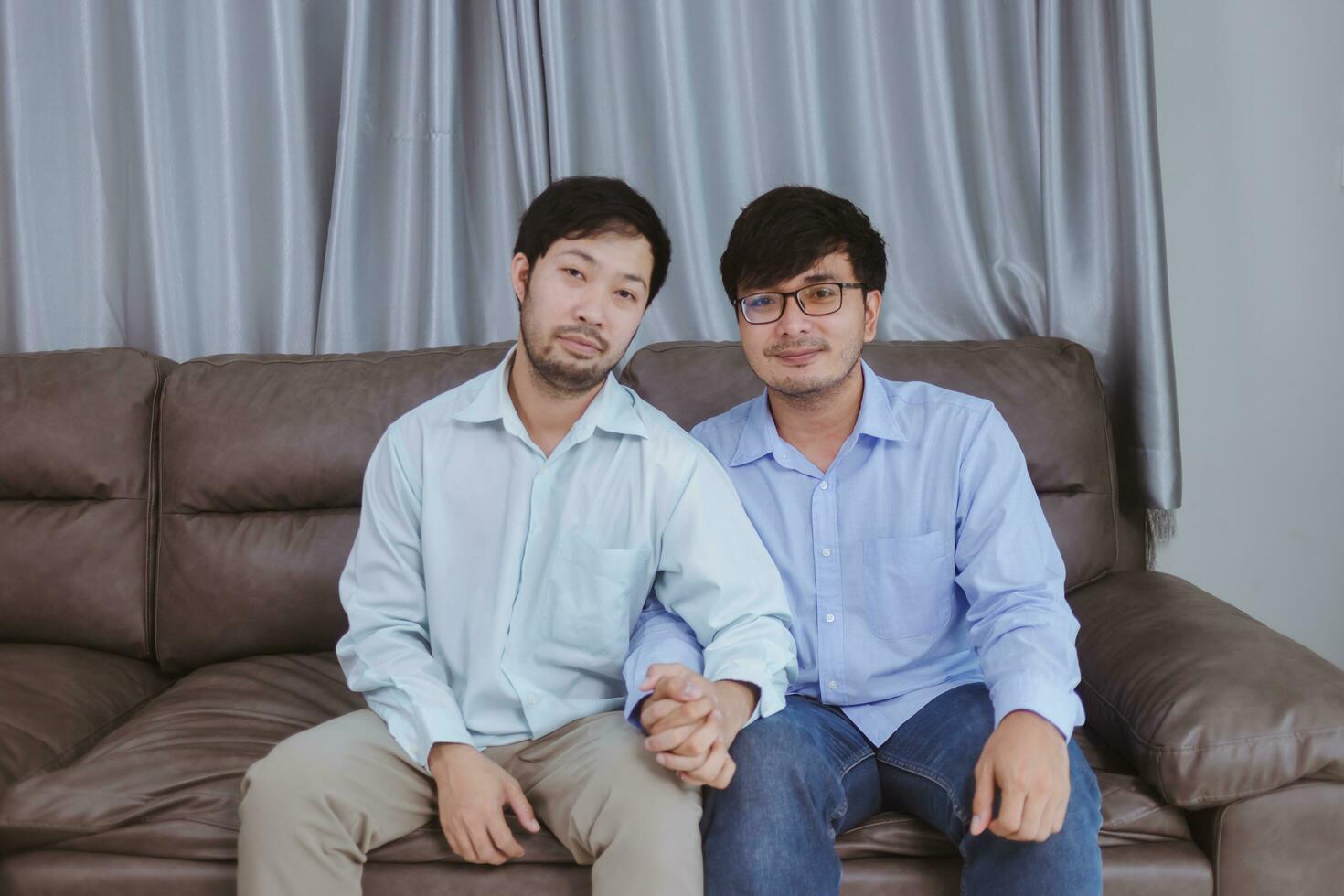 um casal de jovens gays asiáticos mostrando um pouco de carinho, compartilhando um sentimento especial, segurando a mão, feliz por estar juntos. foto