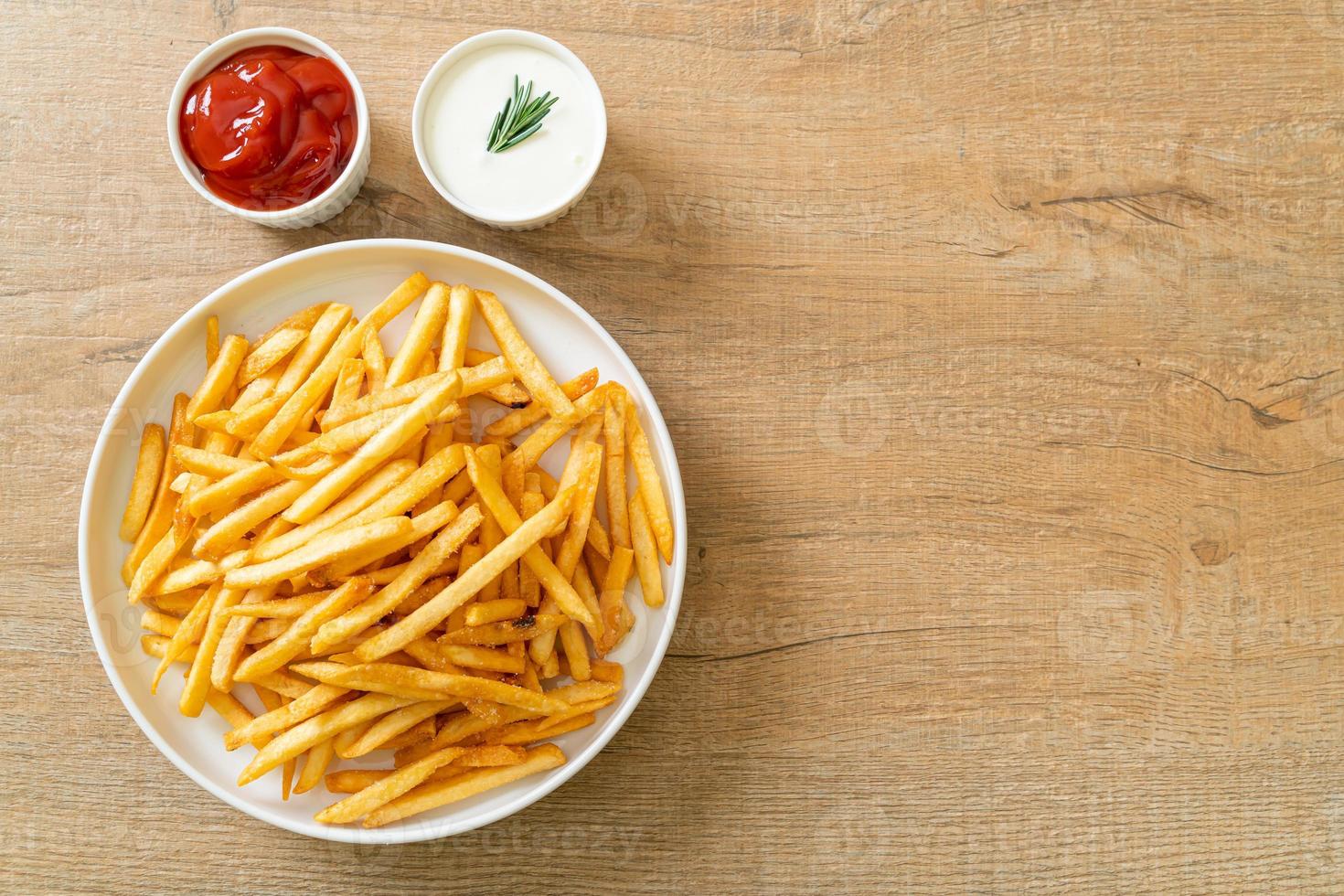 batatas fritas com creme de leite e ketchup foto