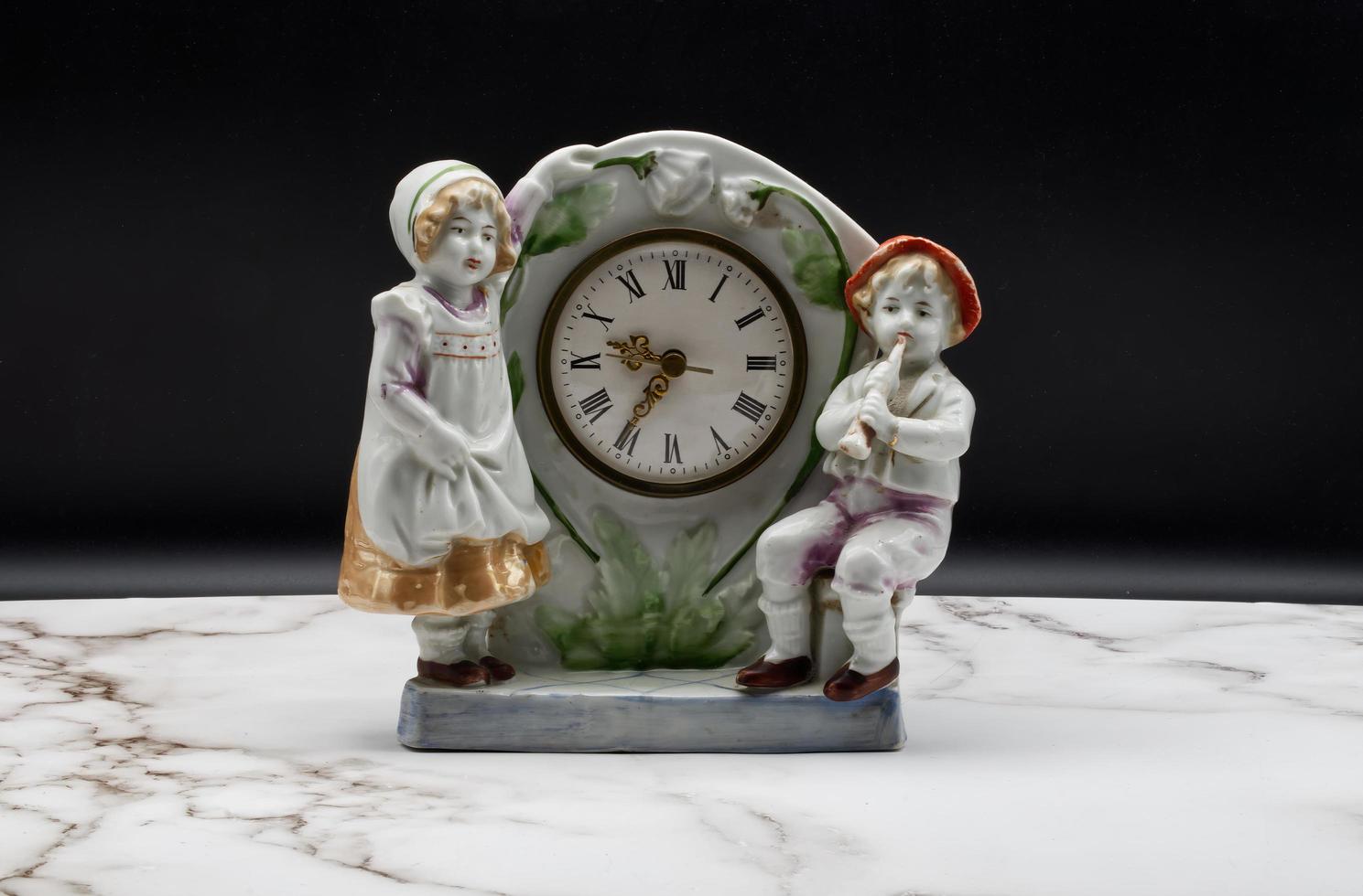 relógio de mesa de cerâmica italiana vintage na mesa de mármore e fundo preto. foto