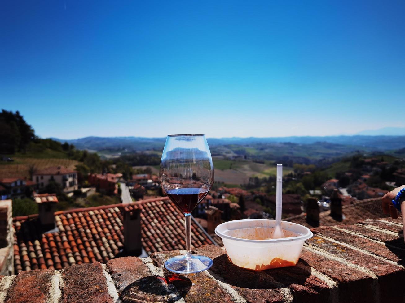 copo de vinho e prato de ravioli com vista para a langhe piemontesa de monforte d'alba foto