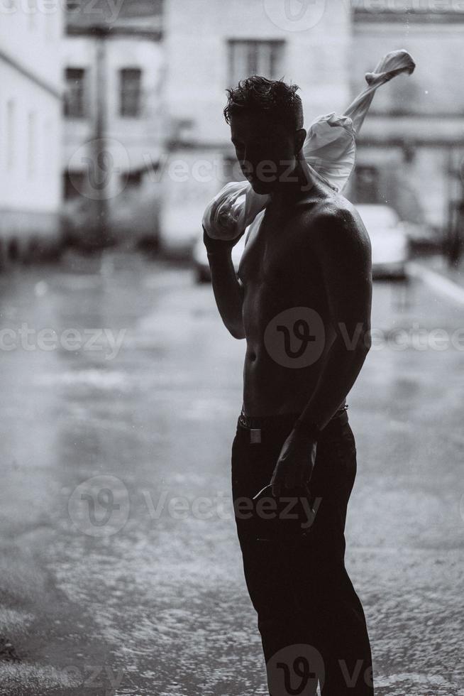 retrato de jovem bonito despreocupado está se sentindo livre sob a chuva foto