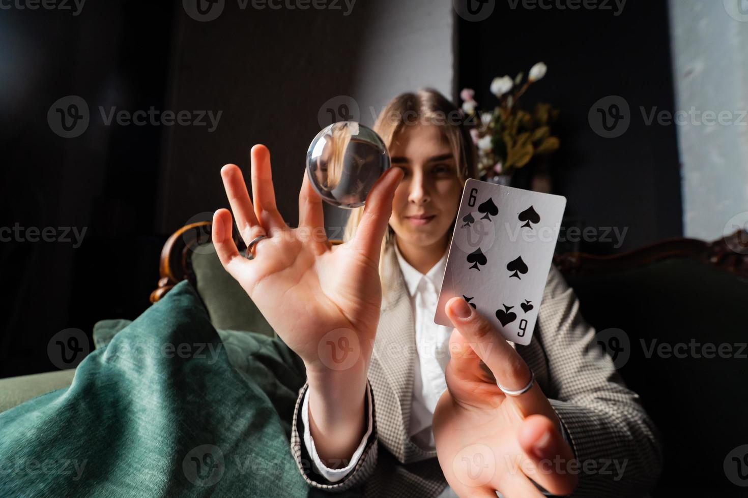 mulher de terno segurando uma bola de cristal e seis pás foto