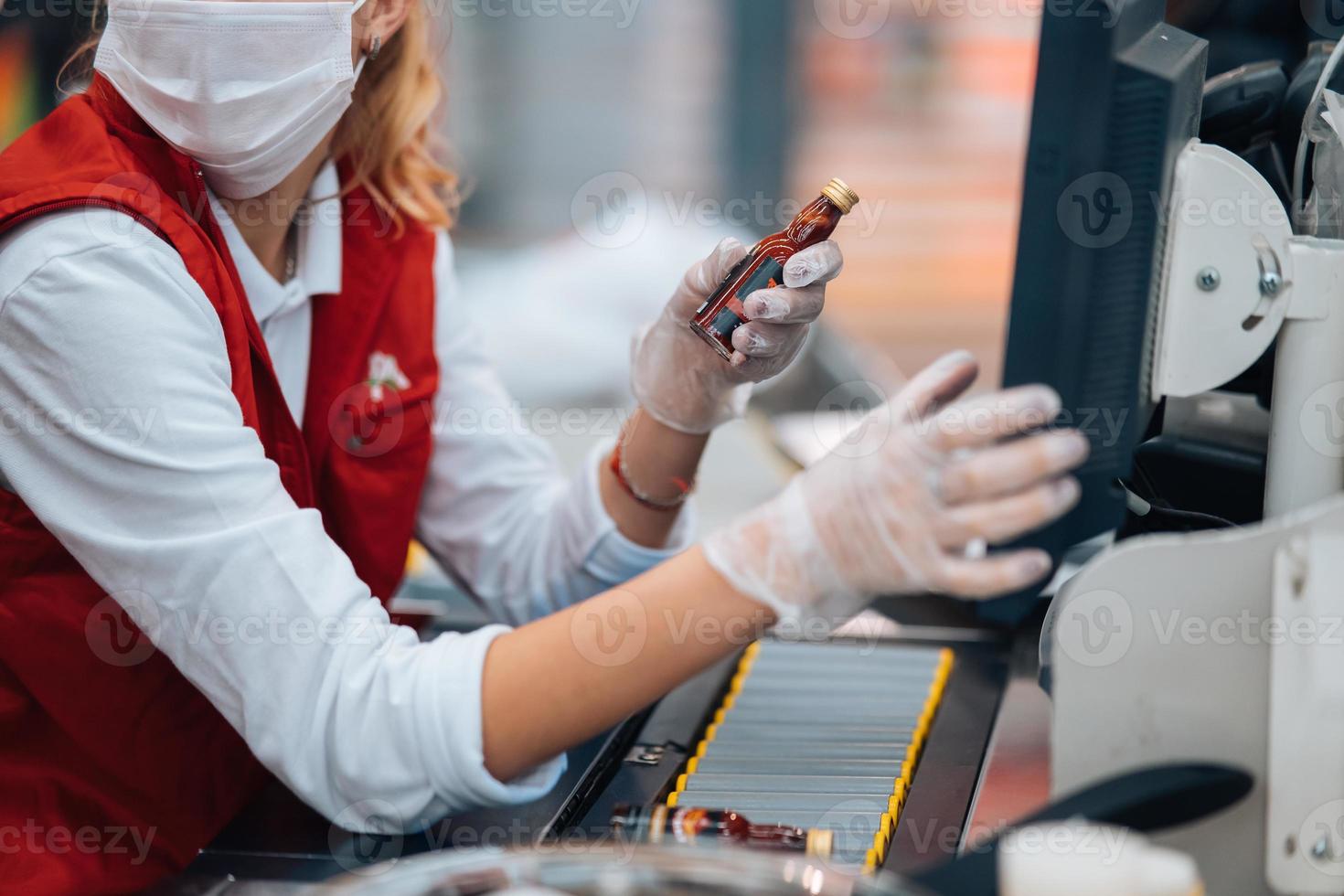 uma mulher lê o código de barras na máquina de checkout no supermercado foto