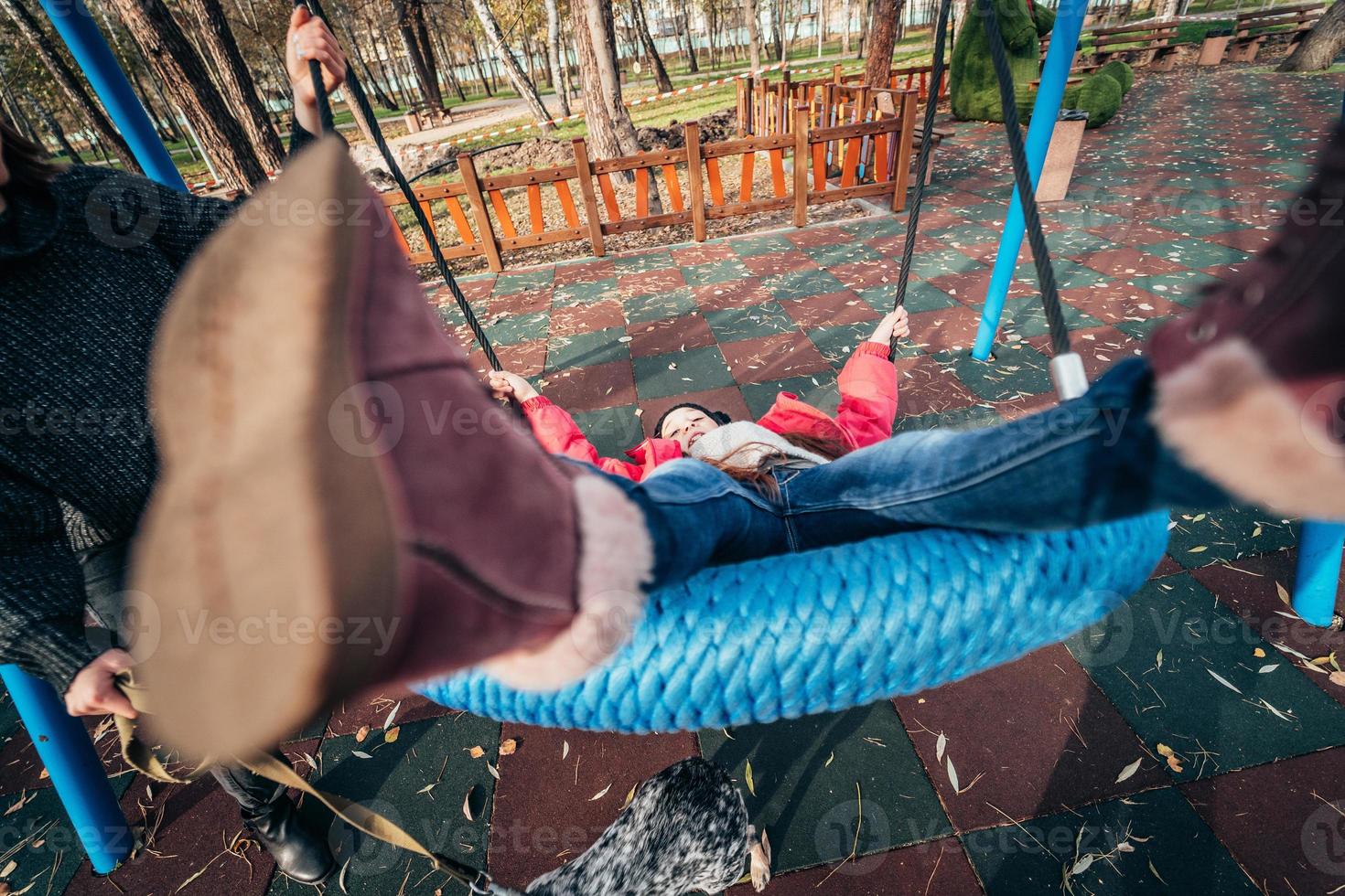 menina criança feliz no balanço. criança brincando no pacote de outono. foto