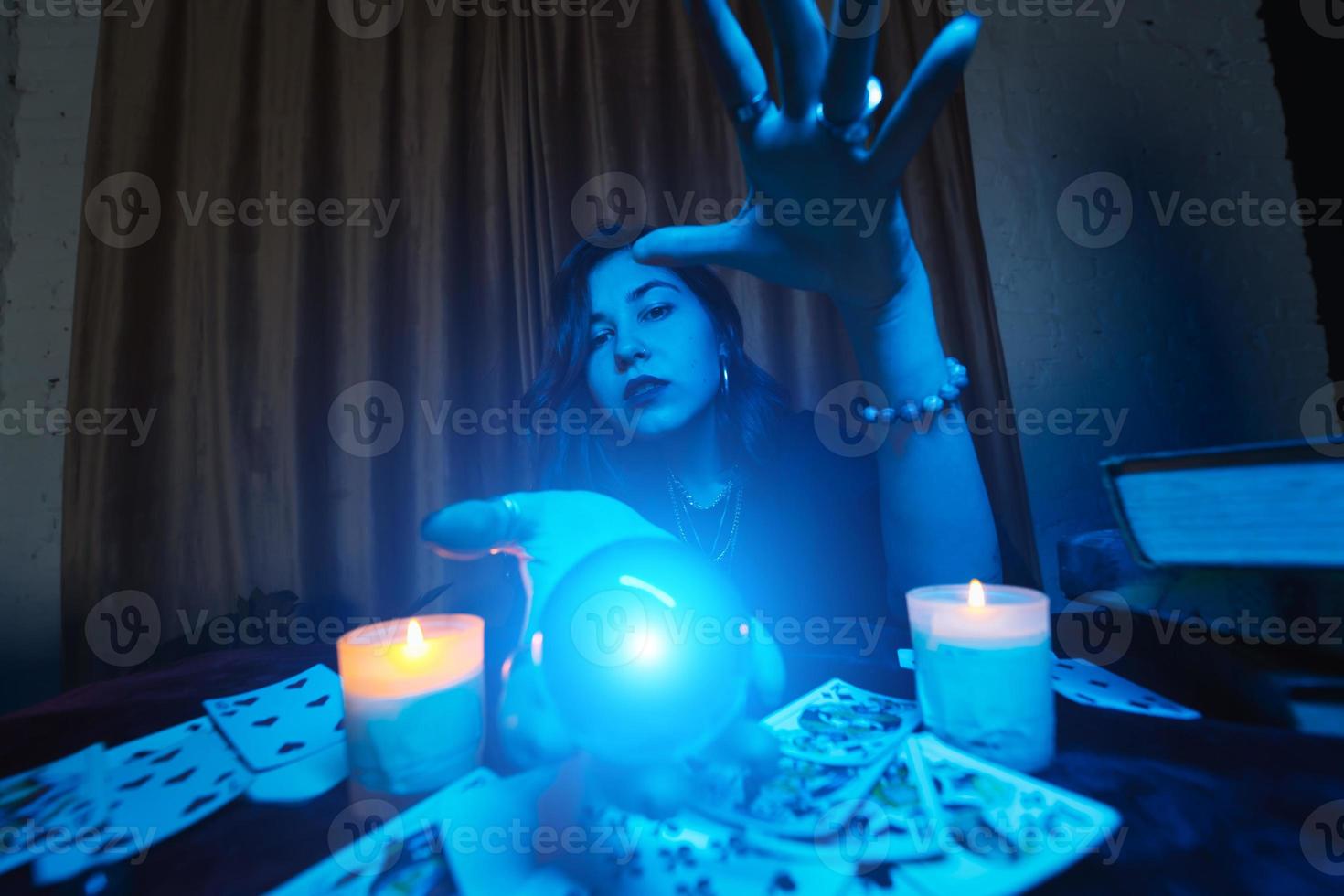 mulher vidente adivinha o destino da noite na mesa com velas foto