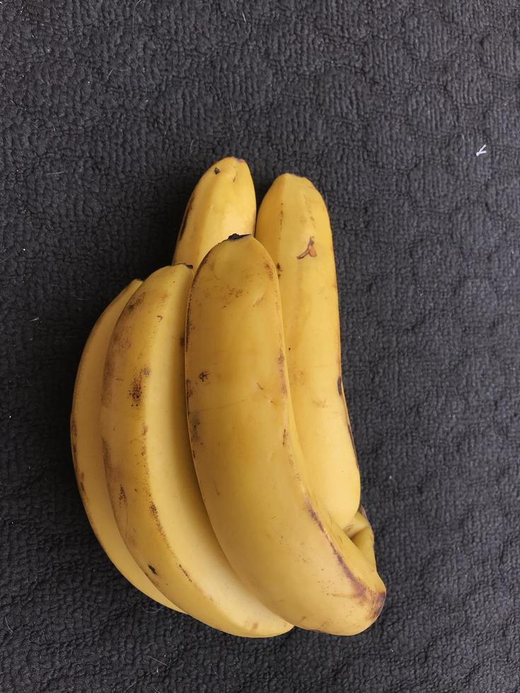 um cacho de bananas em um fundo escuro foto