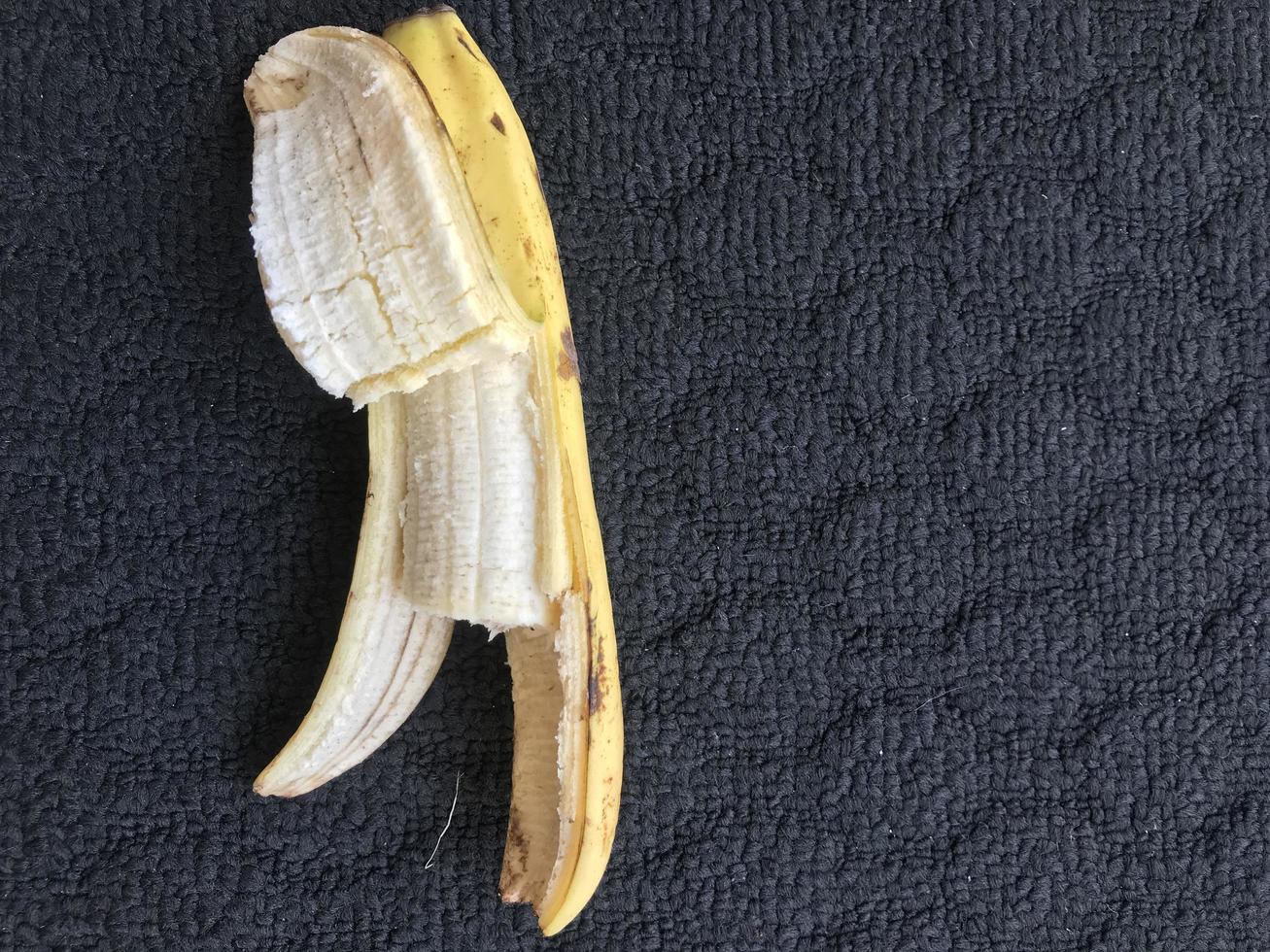 1 banana aberta e em fundo escuro foto