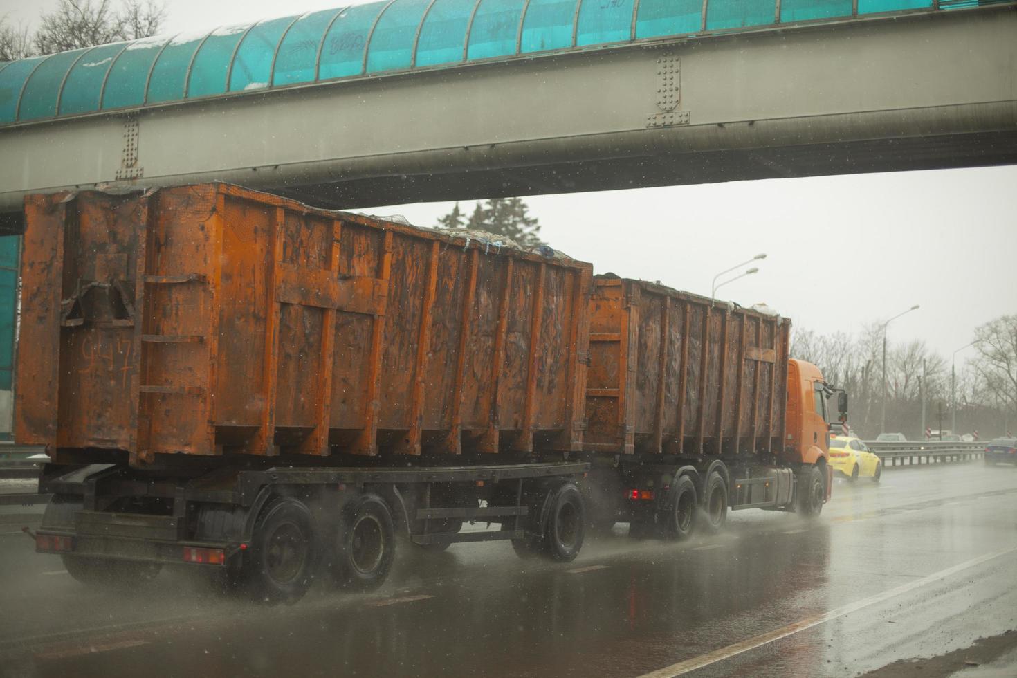 caminhão com corpo laranja. grande reboque. transporte de resíduos. foto