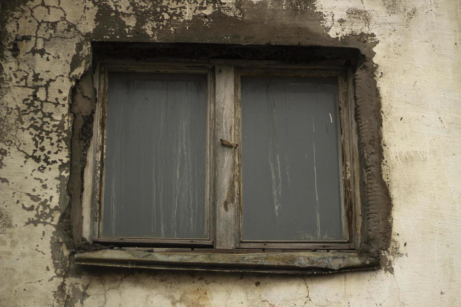 janela velha na parede. parede arruinada com janela de madeira. foto