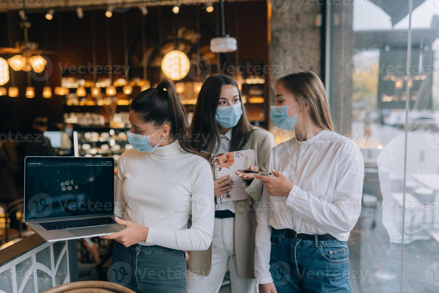 três empresárias com suas máscaras, debatendo diferentes pontos de vista sobre o trabalho foto