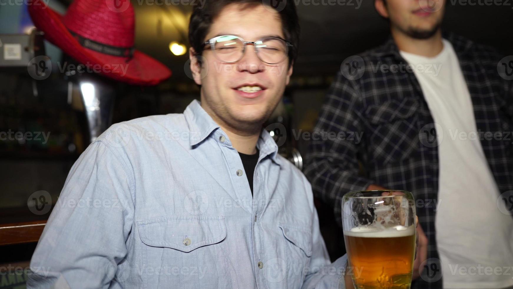 cara com uma cerveja em um bar com amigos em uma noite de sábado foto