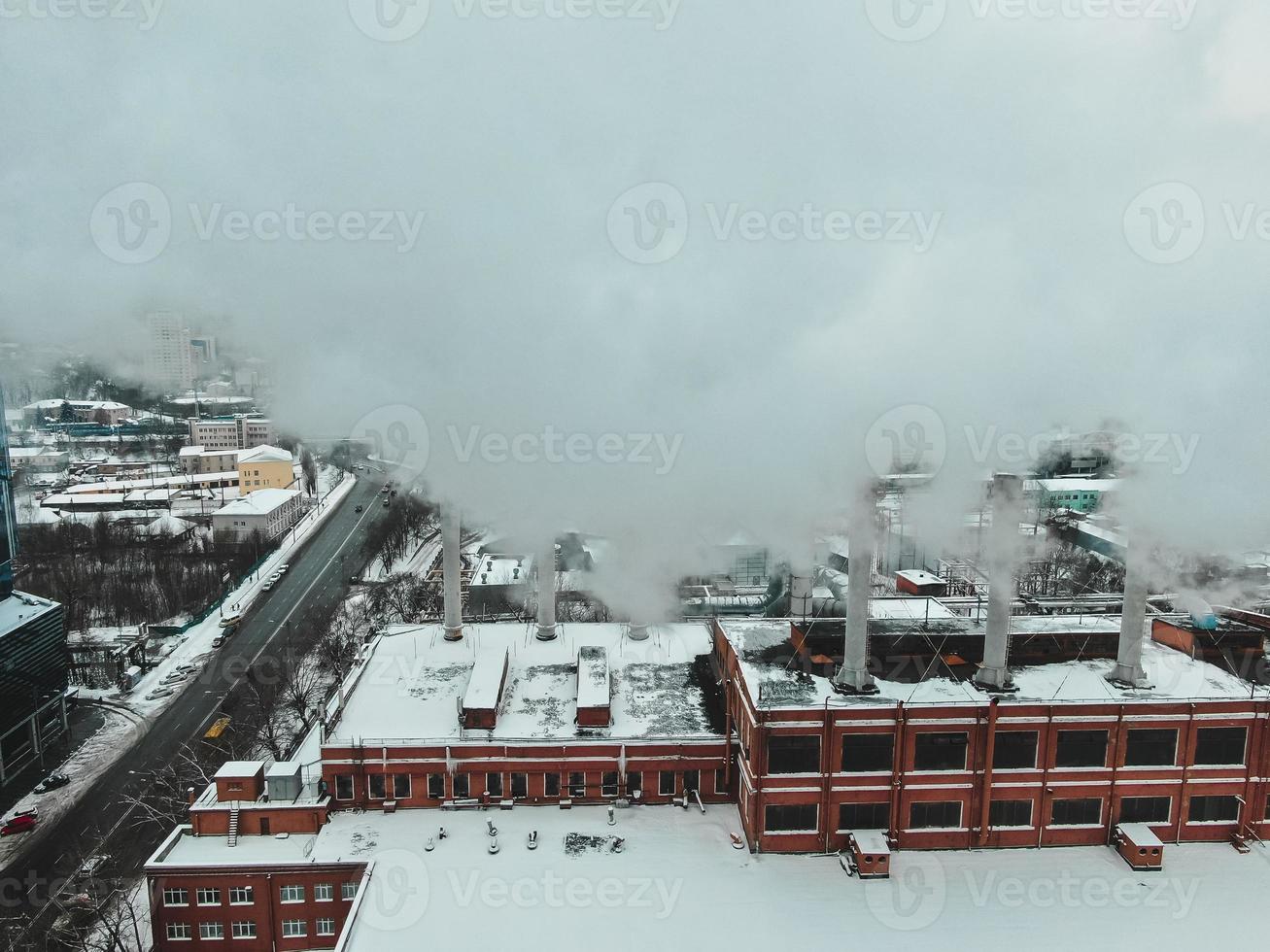 grande sala de caldeira central com tubos gigantes dos quais há fumaça perigosa no inverno durante a geada em uma cidade grande foto