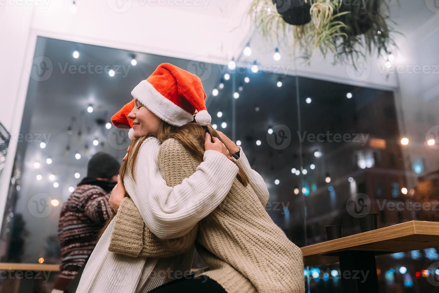 retrato de amigos jovens bonitos felizes abraçando uns aos outros no caffe. foto