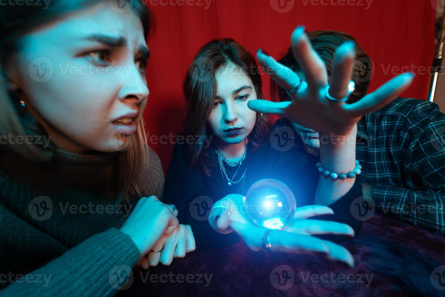 grupo de pessoas e mulher cartomante com bola de cristal foto