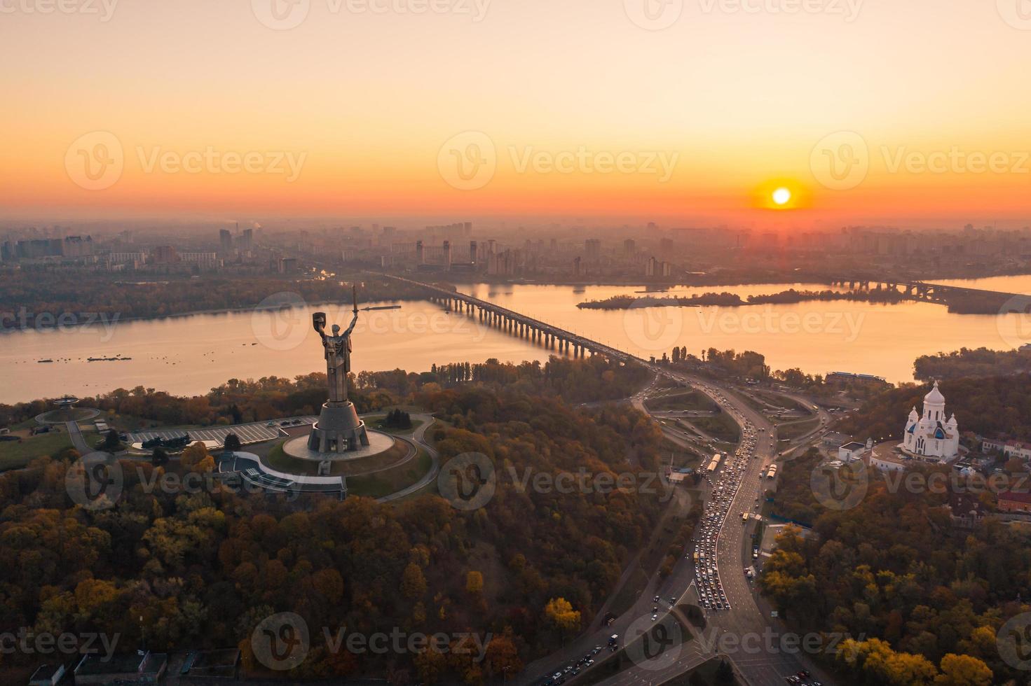 horizonte de kiev sobre o belo pôr do sol ardente, ucrânia. monumento pátria. foto