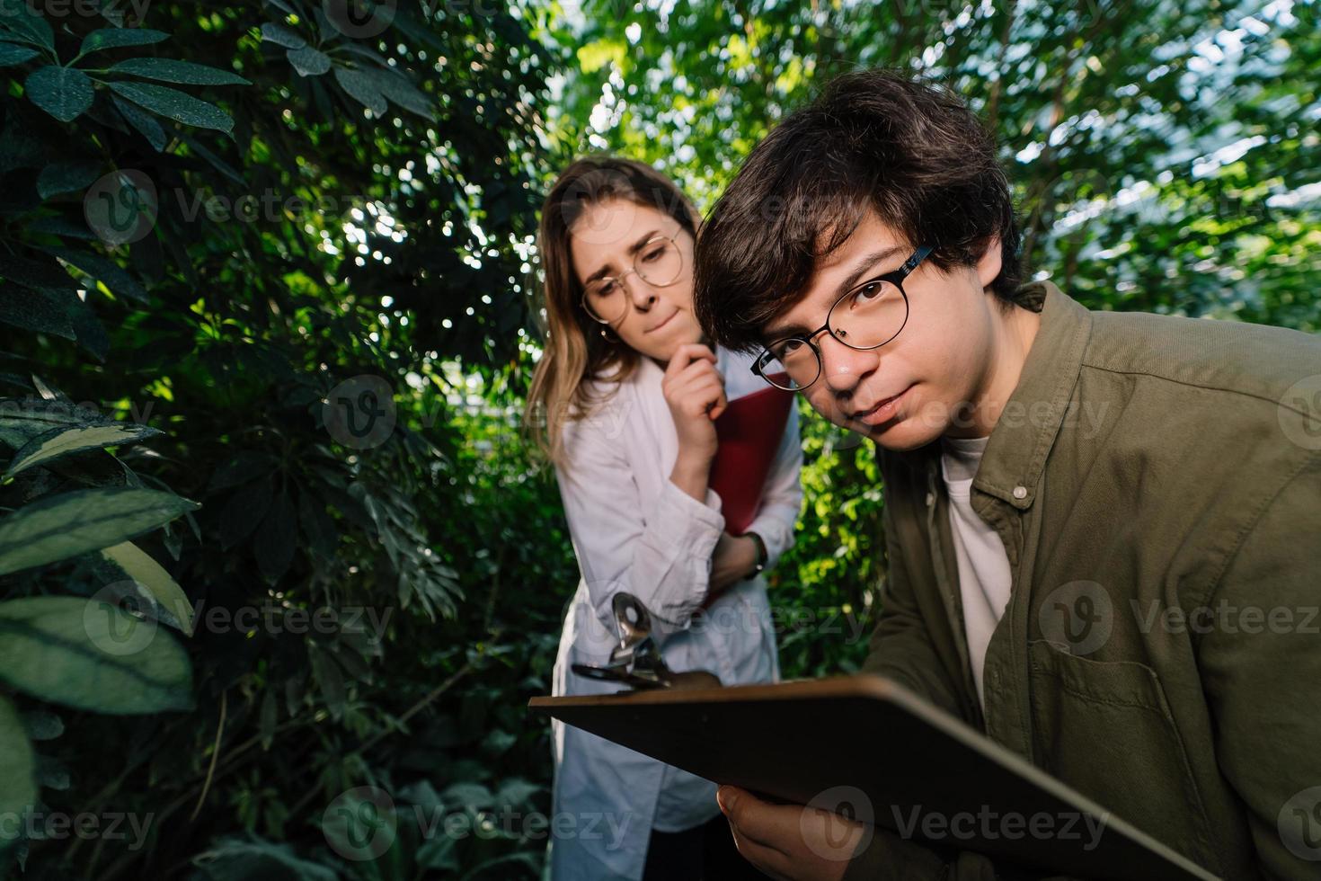 jovens engenheiros agrícolas trabalhando em grande estufa foto