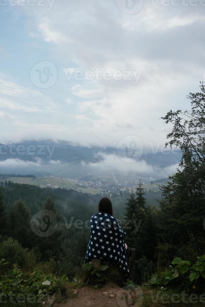 mulher no topo de uma colina, no contexto de um vale foto
