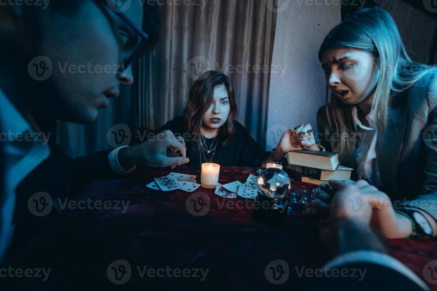 as pessoas dão as mãos da noite à mesa com velas foto