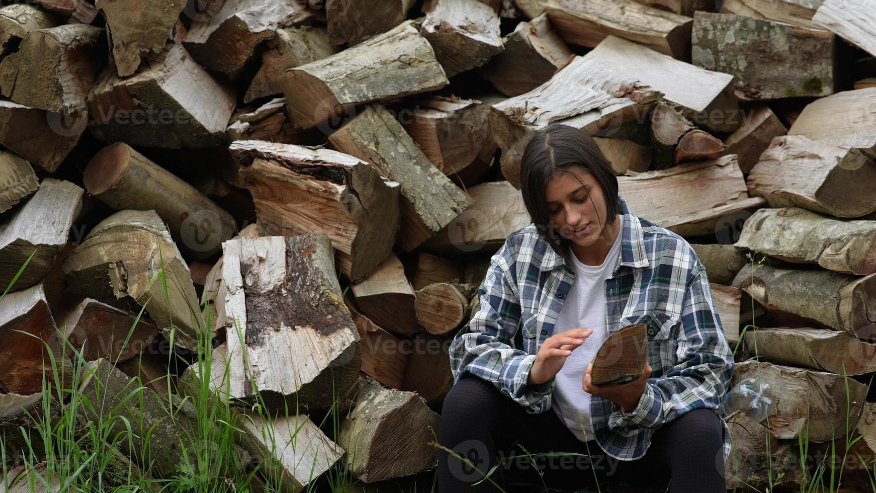 mulher na floresta perto do poste de madeira picada foto