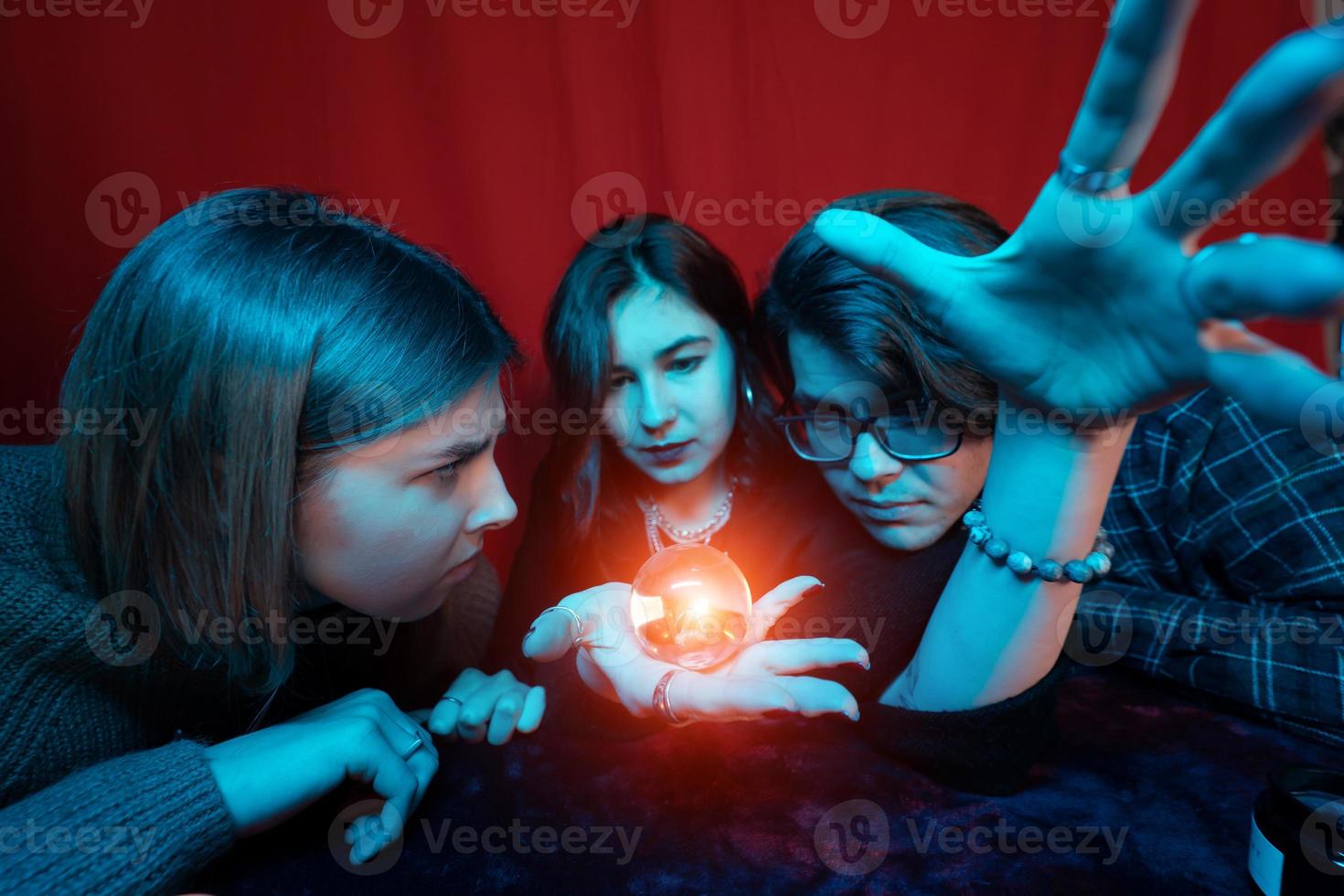 grupo de pessoas e mulher cartomante com bola de cristal foto