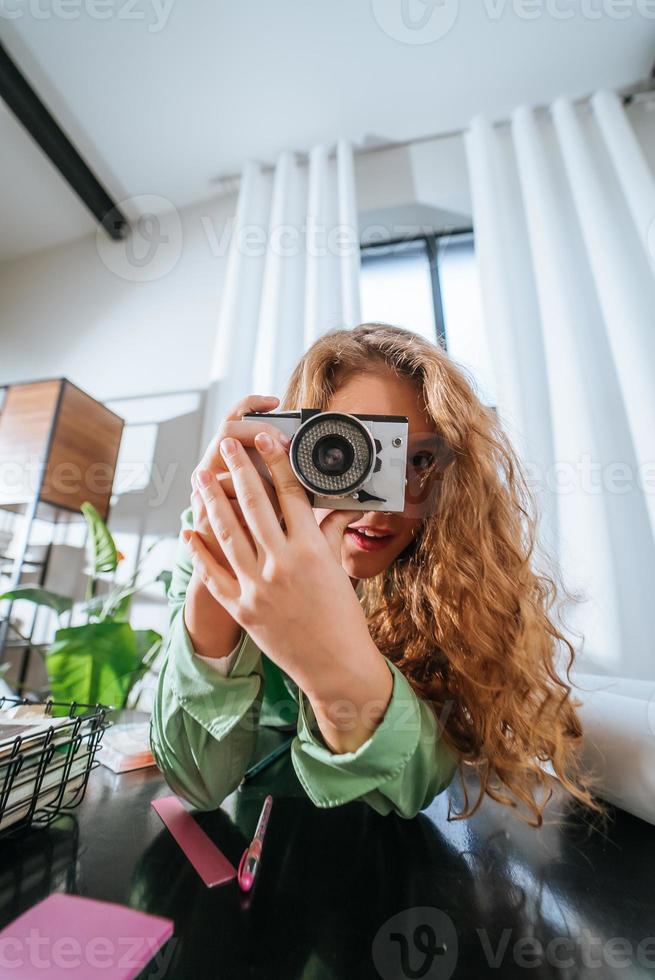 jovem alegre fazendo foto na câmera em casa