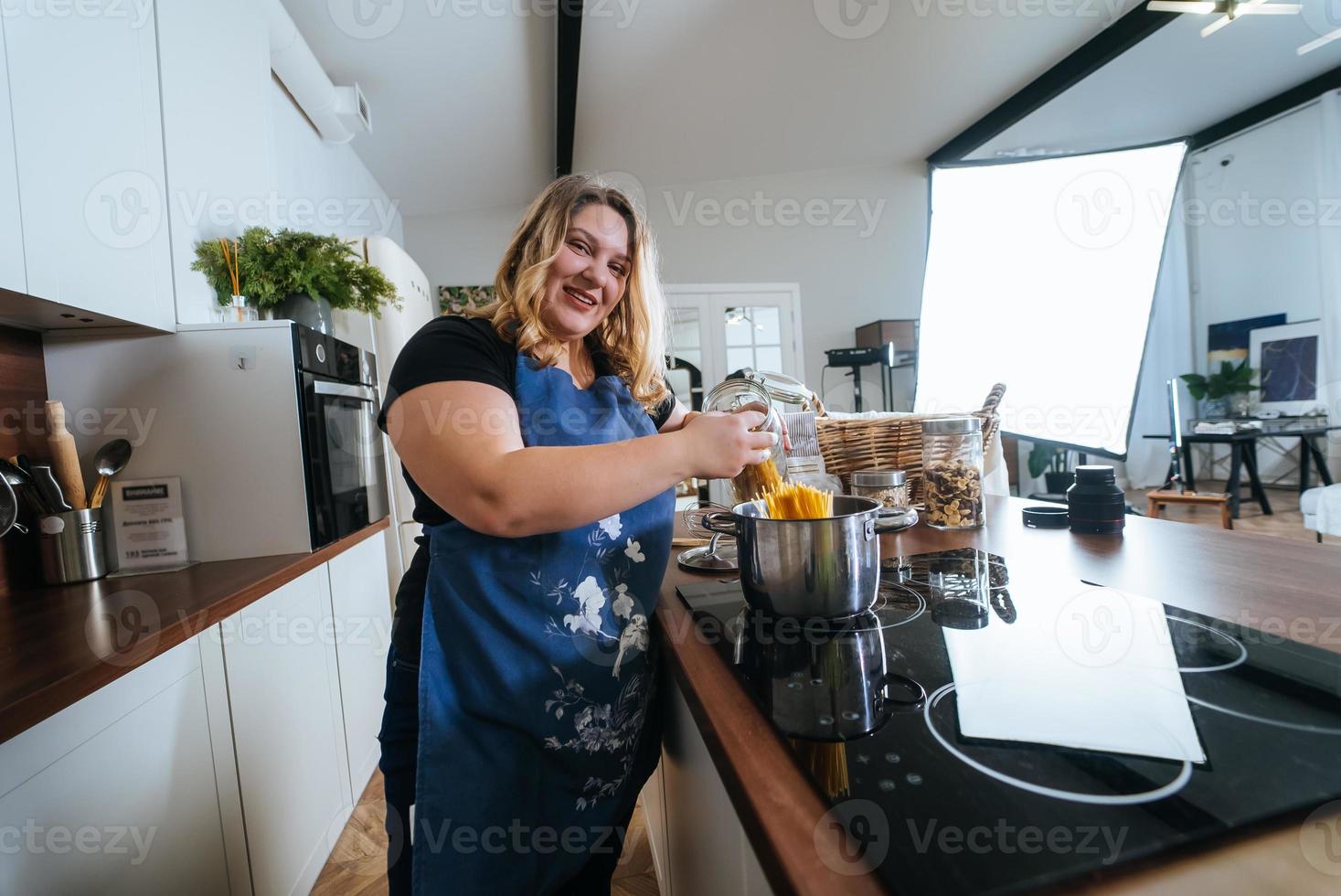 cozinhar - mulher na cozinha moderna, preparando espaguete foto