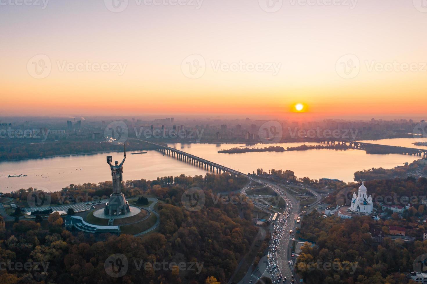horizonte de kiev sobre o belo pôr do sol ardente, ucrânia. monumento pátria. foto