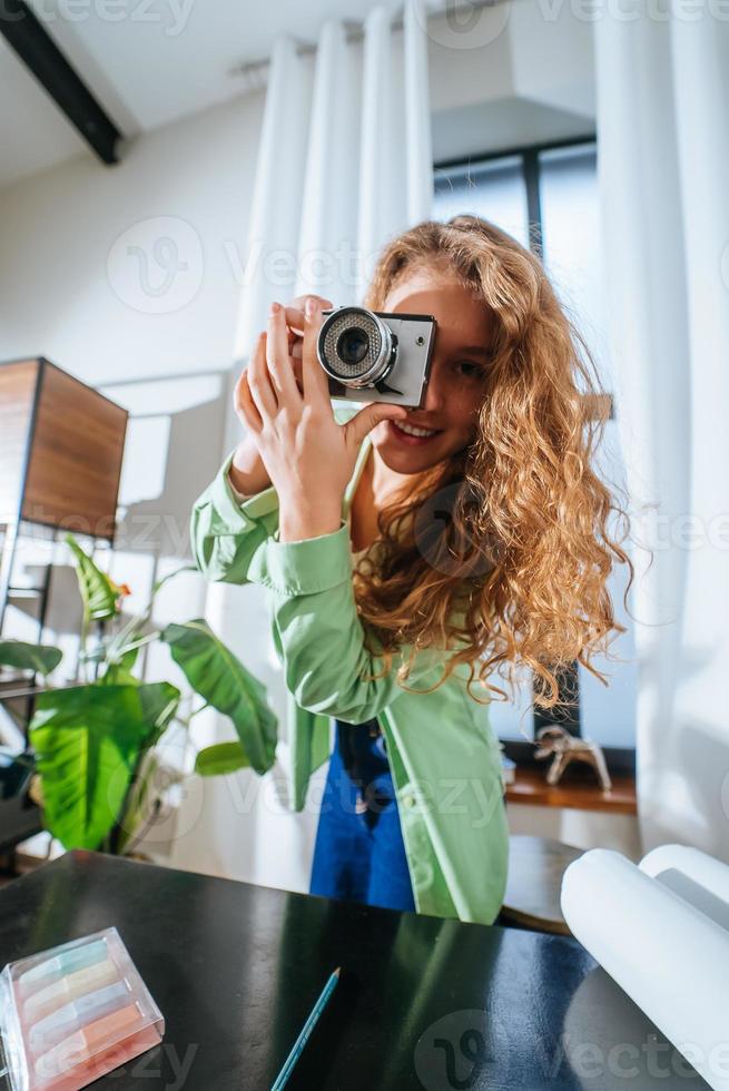 jovem alegre fazendo foto na câmera em casa