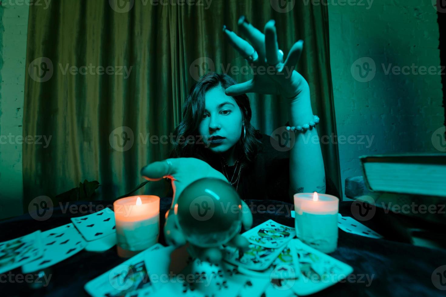 mulher vidente adivinha o destino da noite na mesa com velas foto