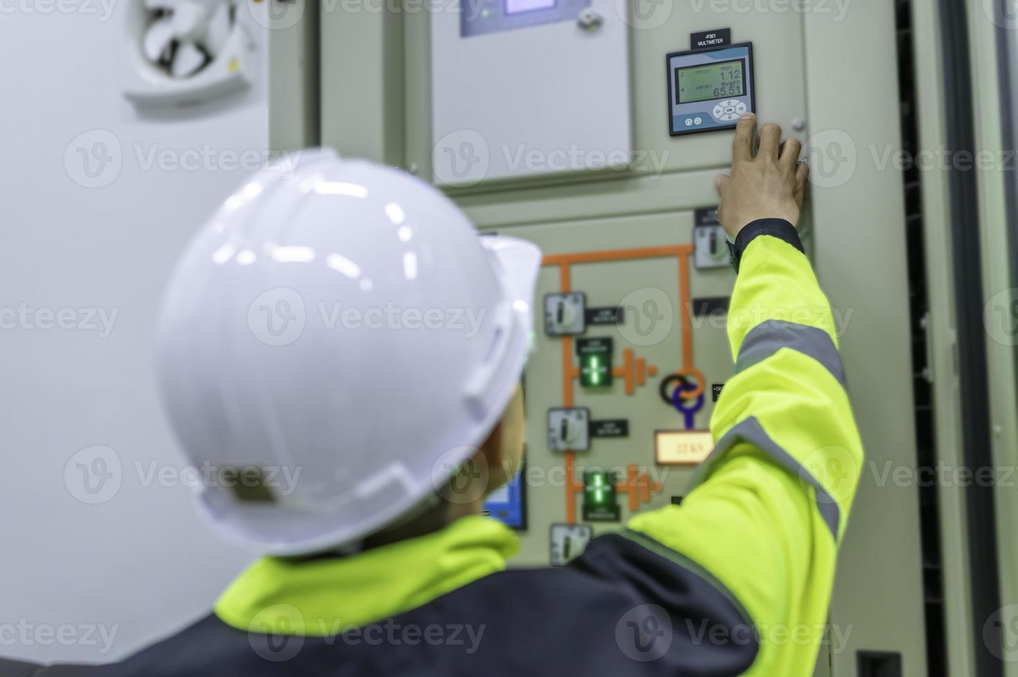 homem engenheiro elétrico verificando a tensão no gabinete de distribuição de energia na sala de controle, manutenção preventiva anualmente, eletricista tailandês trabalhando na empresa foto