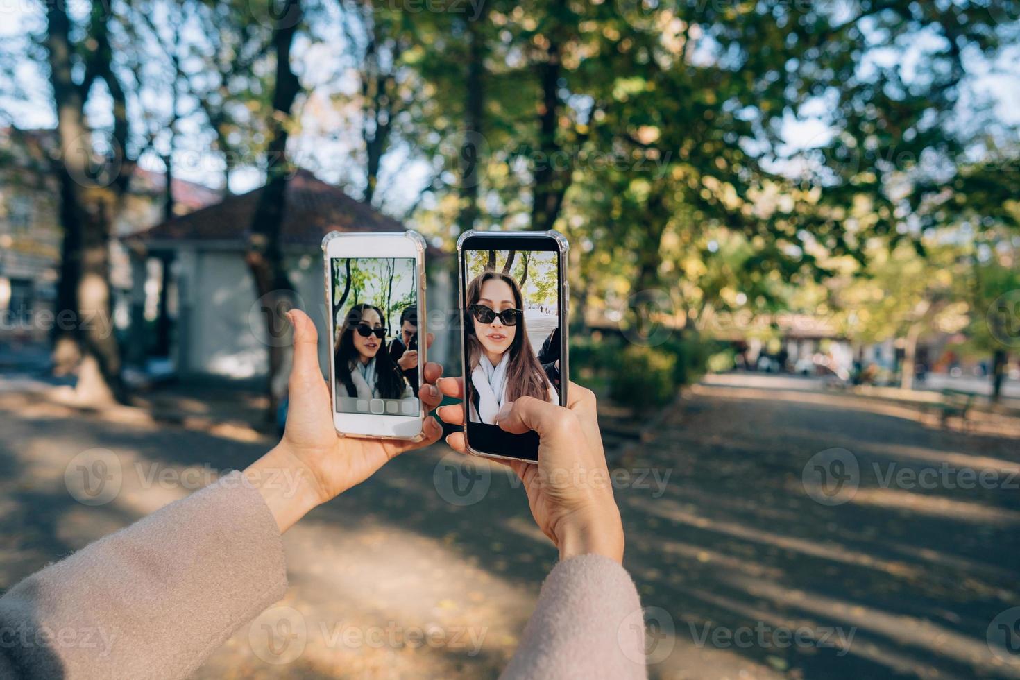 linda jovem tem nas mãos dois smartphones foto