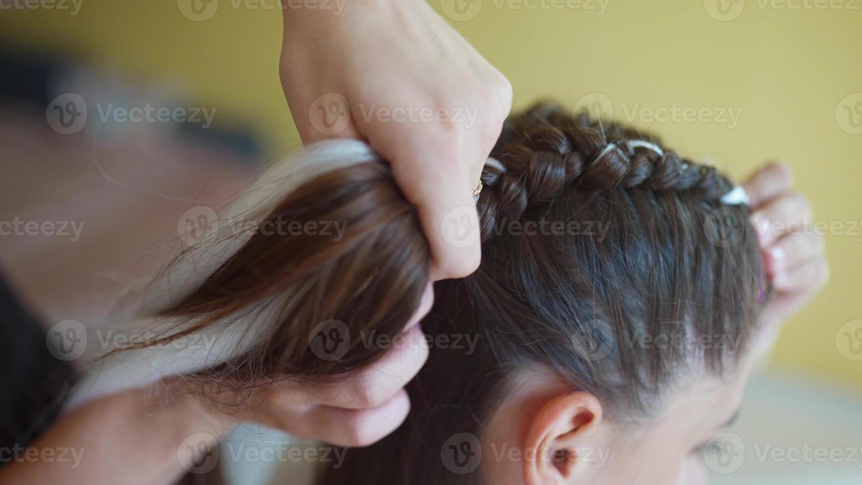 processo de trança. mestre tece tranças na cabeça em um salão de beleza, close-up foto