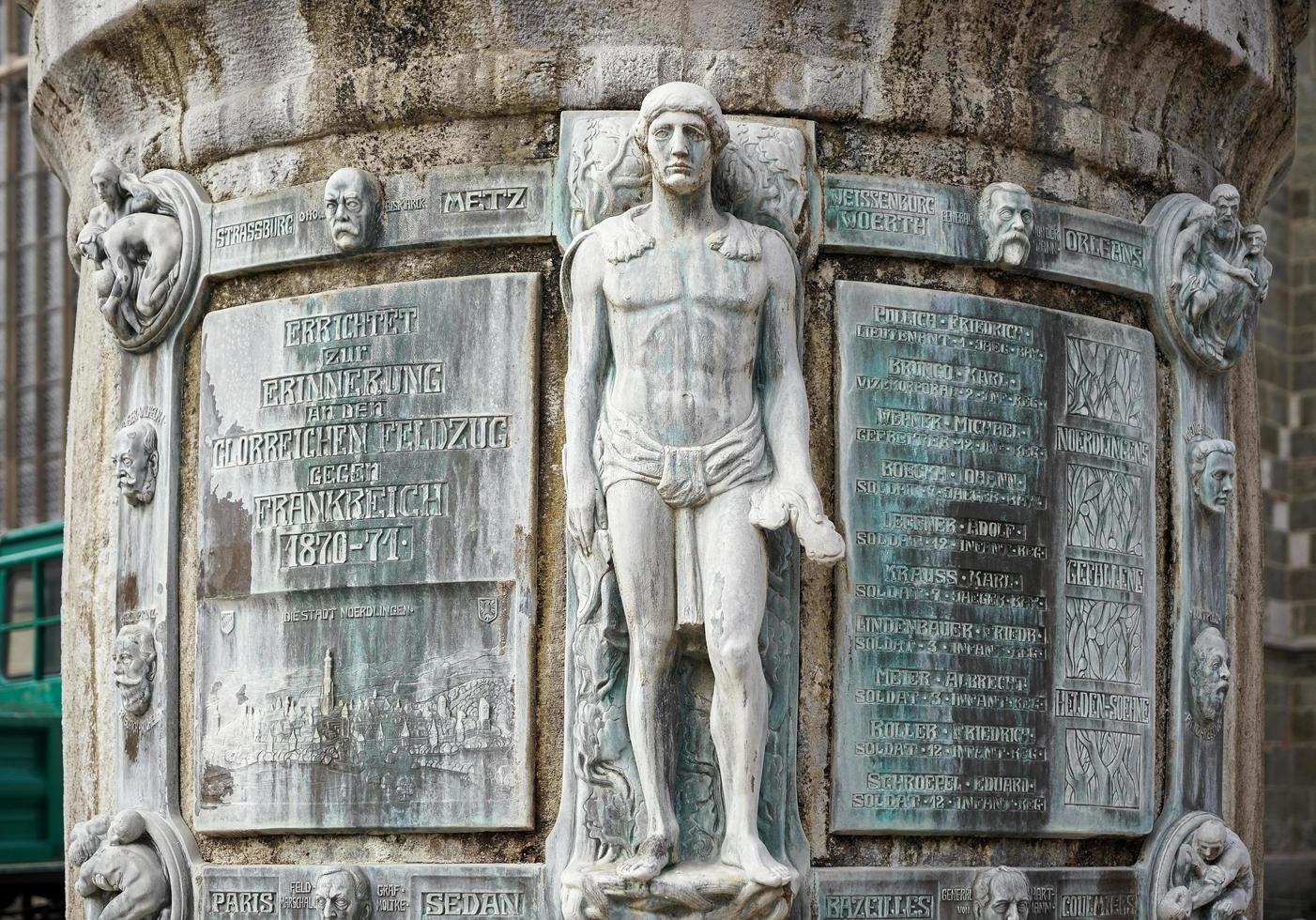 nordlingen, alemanha, 2014. coluna alta e estátua do lado de fora da igreja de st georges em nordlingen foto