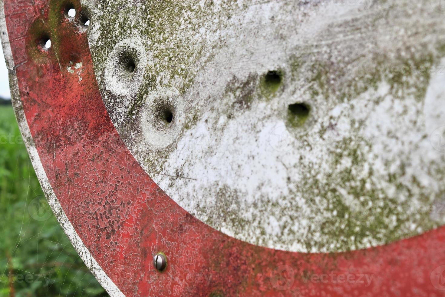 close-up detalhado de buracos de bala de tiros em um sinal de trânsito foto