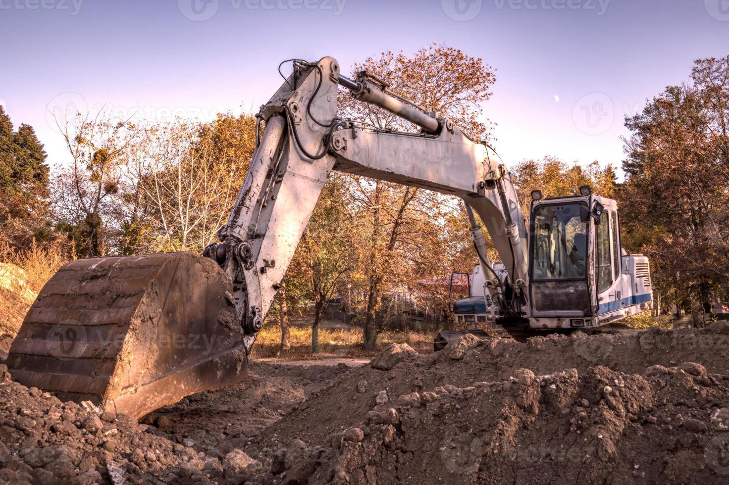 descanso, grande escavadeira com pá no canteiro de obras. visão horizontal foto