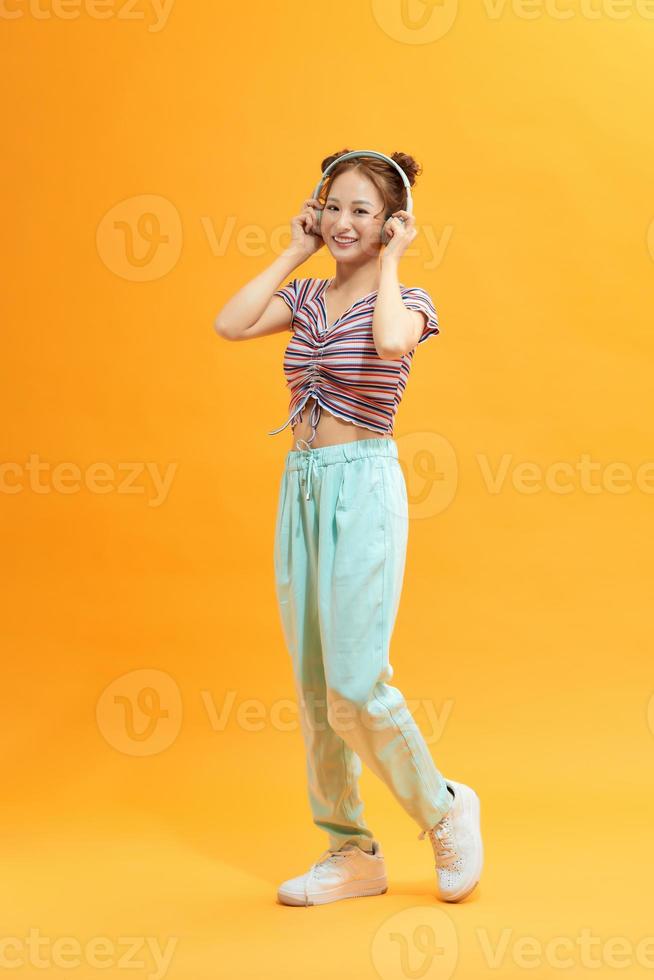 imagem de mulher jovem feliz fazer gesto de vencedor sobre fundo amarelo. olhe para a câmera. foto