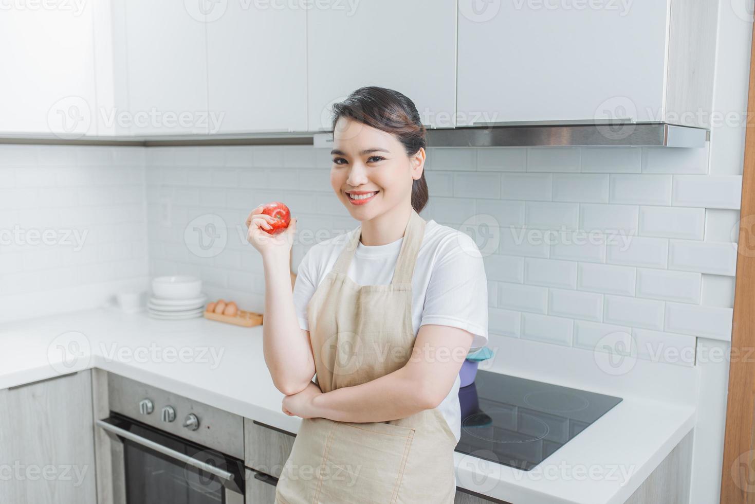 jovem mulher asiática cozinhando na cozinha. cozinhar em casa. comida saudável. conceito de dieta. foto